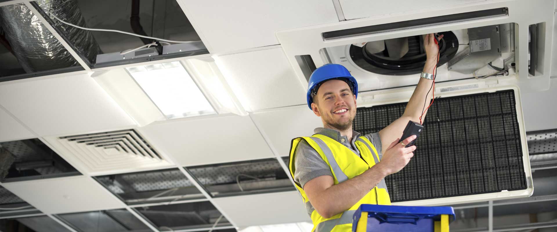 Man checking a ducted air conditioner | LCM Air Conditioning
